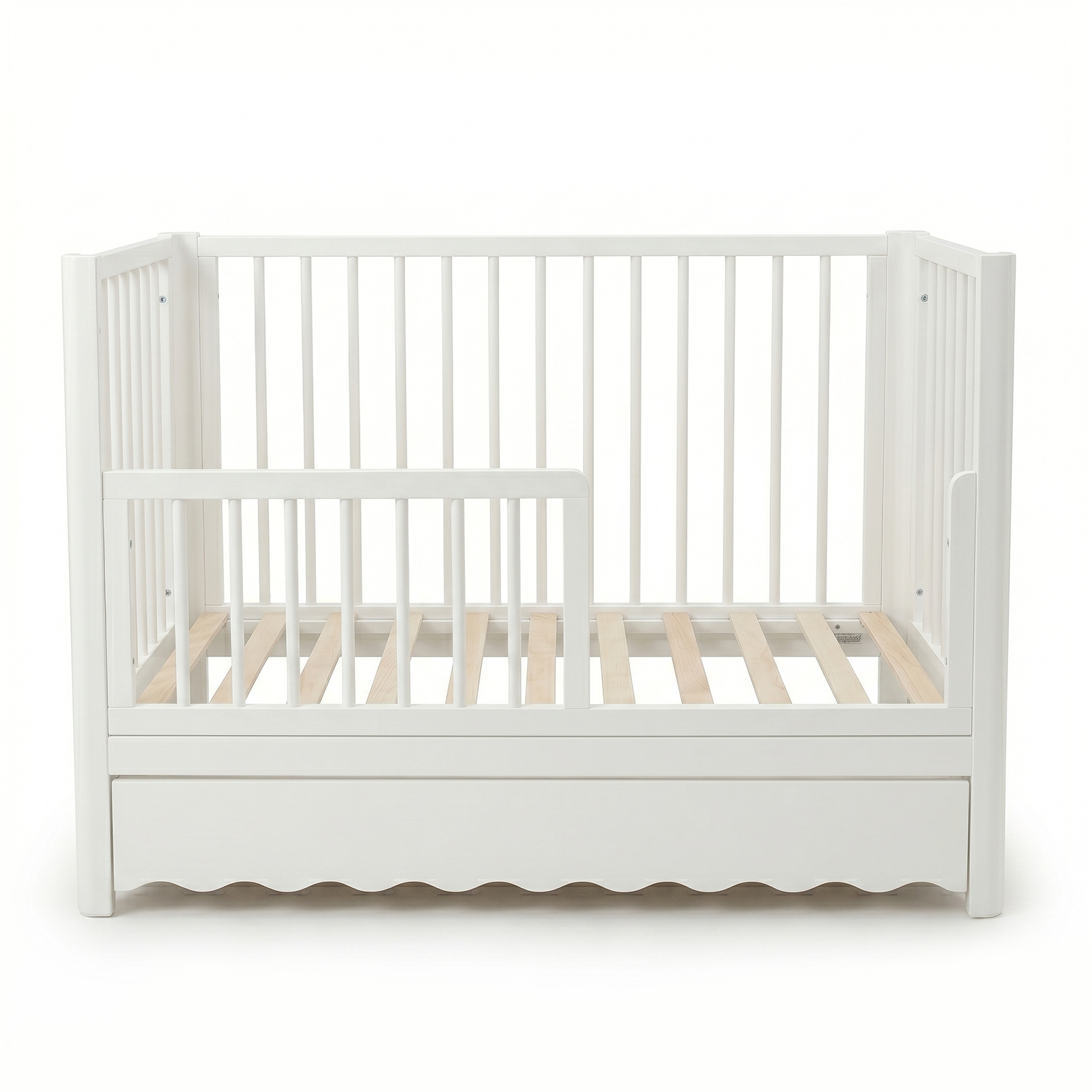 White toddler crib with underbed drawer on white background