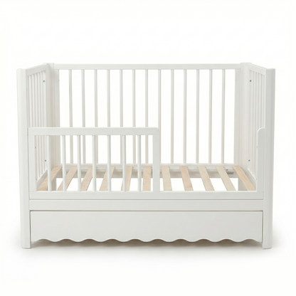 White toddler crib with underbed drawer on white background