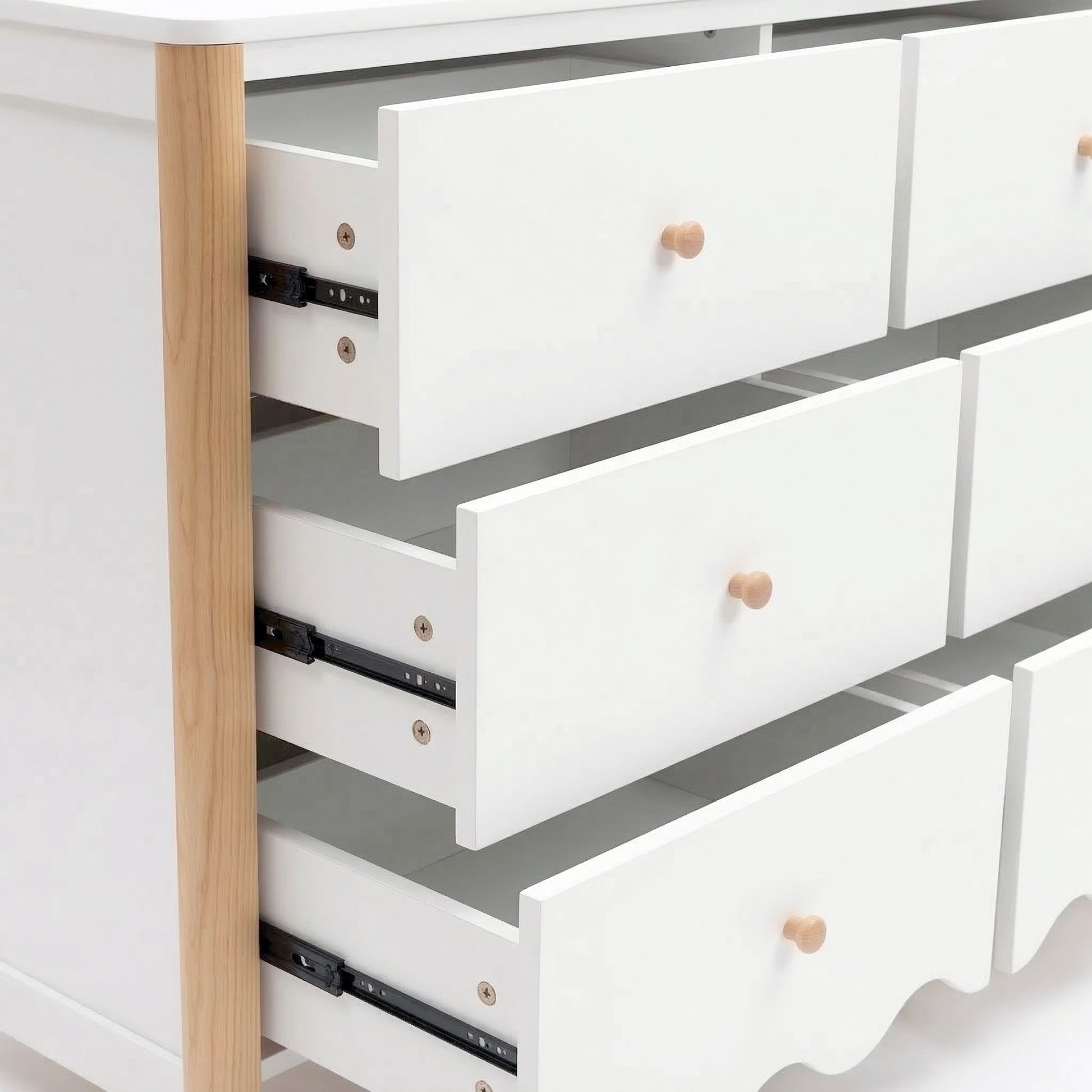 Close-up side view of white dresser drawers and metal sliding mechanism on white background
