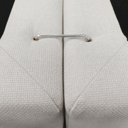 Close-up of a chrome connector between two beige upholstered sections