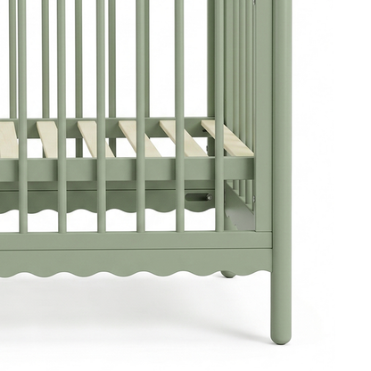Close-up of the lower slats of a sage green crib