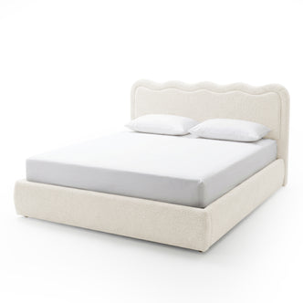Off-white upholstered king bed with wavy headboard on white background