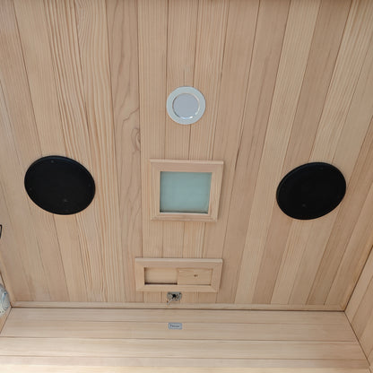 Wooden sauna ceiling with vents, lights, and speaker-like features.