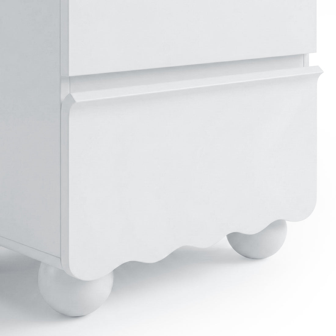 Close-up of scalloped lower edge and ball foot of white cabinet