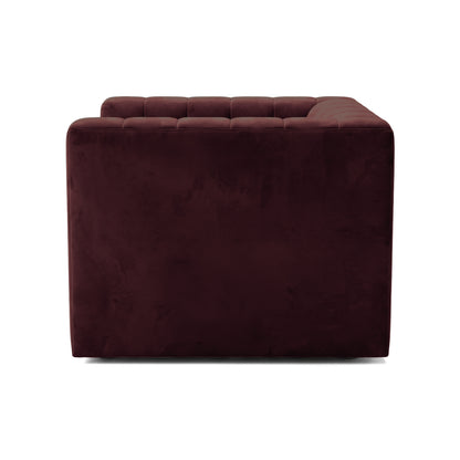 Partial side view of a burgundy sofa piece on a white background