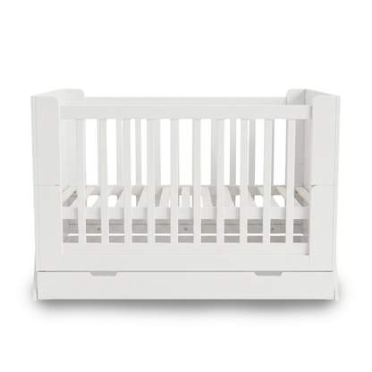 White baby crib on white background full front view with drawer