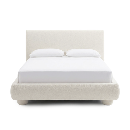 Full upholstered bed with pillows on a white background