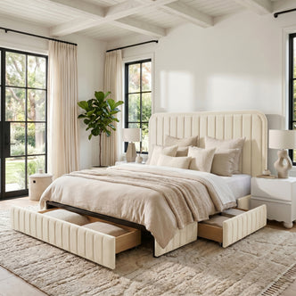 Cream upholstered bed in a sunlit bedroom setting with plants and decor