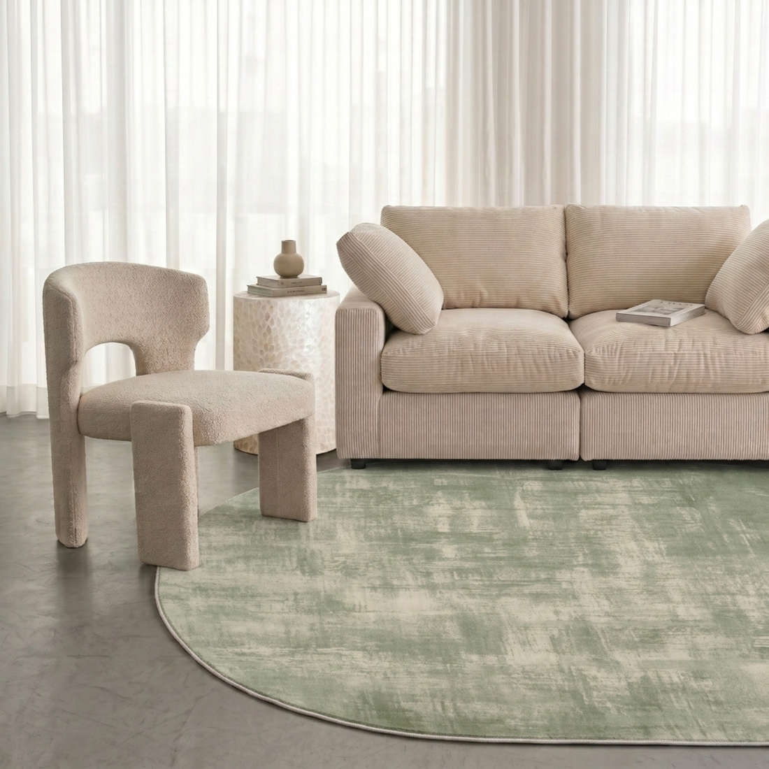 Sage green rug styled in a modern living room with a sofa, chair, and side table