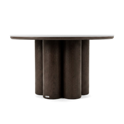 Round dark wood table with a six-column base on a white background