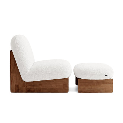 Side profile view of lounge chair and ottoman on white background.