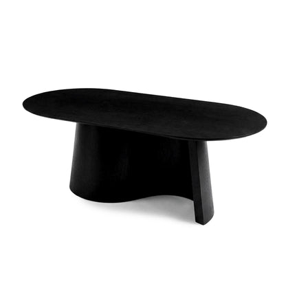Full view of a minimalist black coffee table with asymmetrical oval top and sculptural base on white background