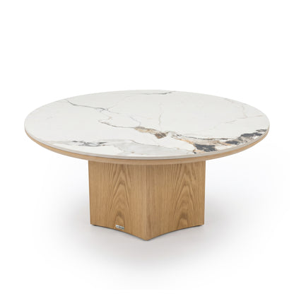 Round table with a thick marble-effect top and light wood base on a white background.