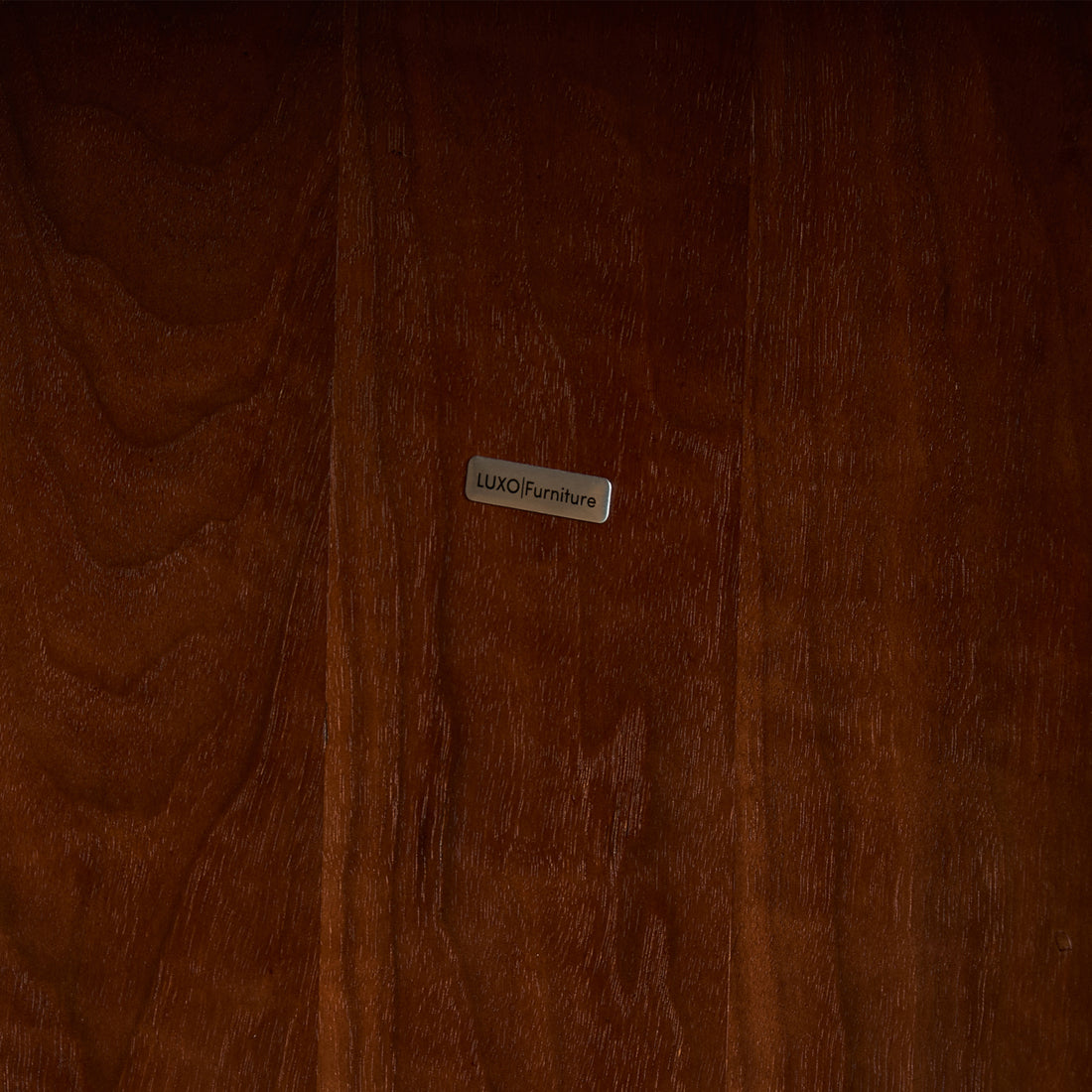 Close-up of polished wood surface with a metal brand label