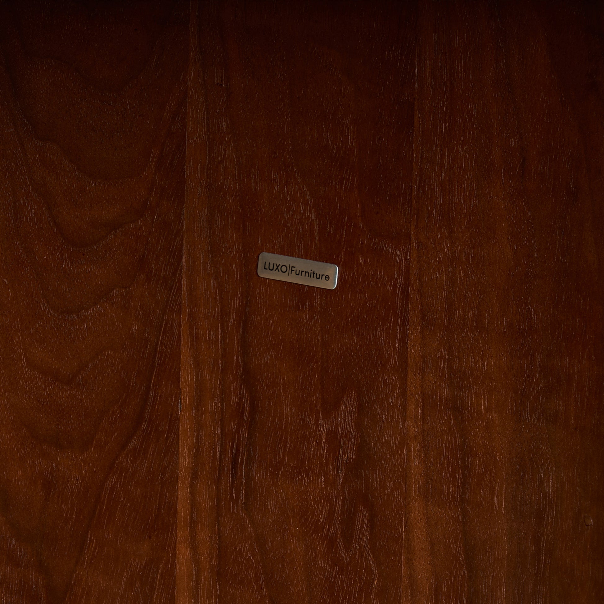 Close-up of polished wood surface with a metal brand label