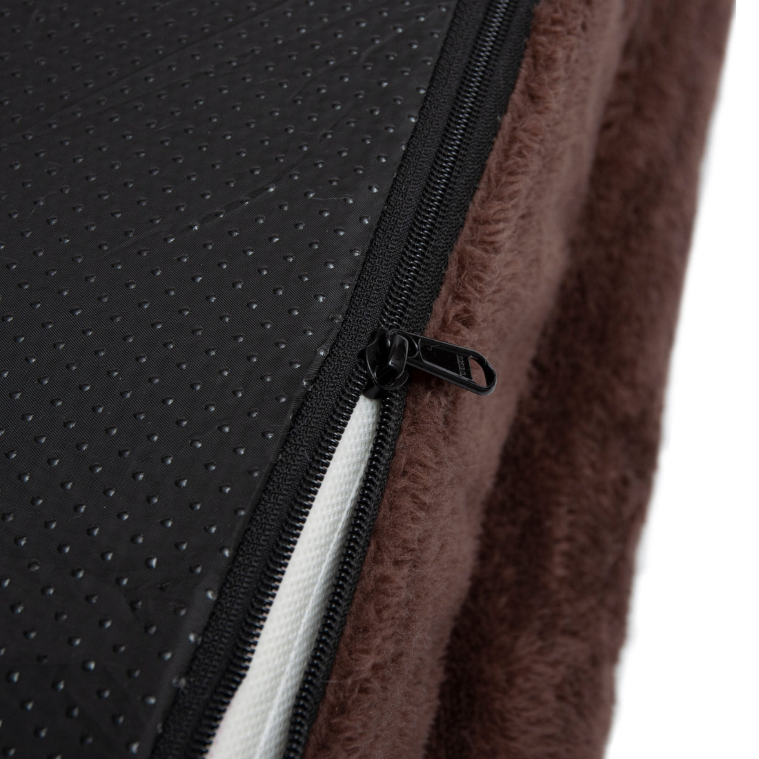 Close-up of zipper and fabric details on brown plush material