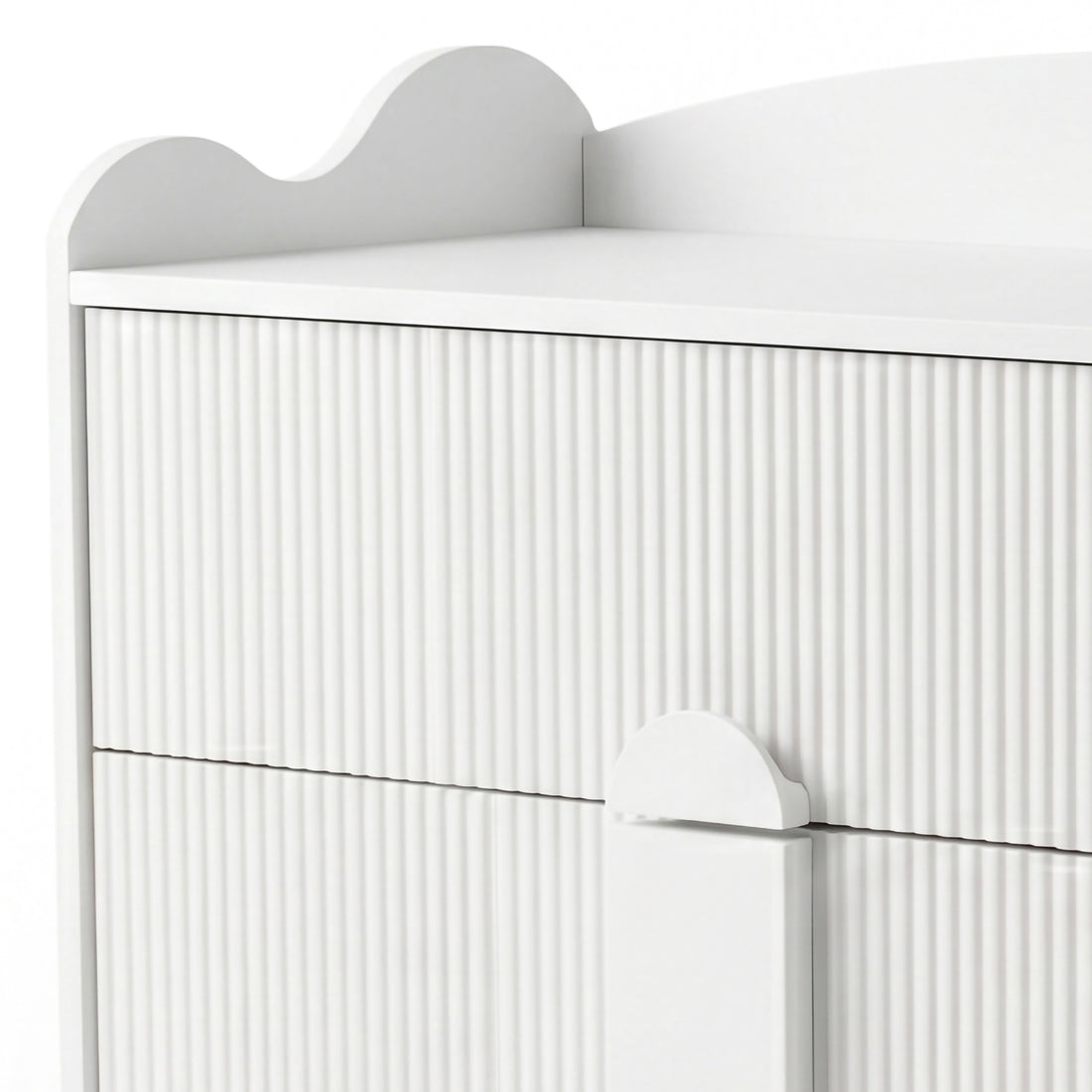 Upper section of white dresser with grooved texture and scalloped top edge