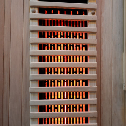 Close-up of a sauna heater with glowing heating elements behind a grill