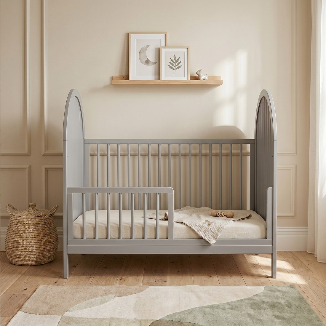 Light gray crib in styled nursery room with shelf and decor