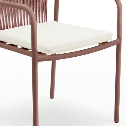 Evone 4 Seater Stone Outdoor Dining Table Set features a slim, tubular metal chair frame with a muted reddish-brown finish, white cushion, and woven backrest, highlighting modern outdoor elegance.