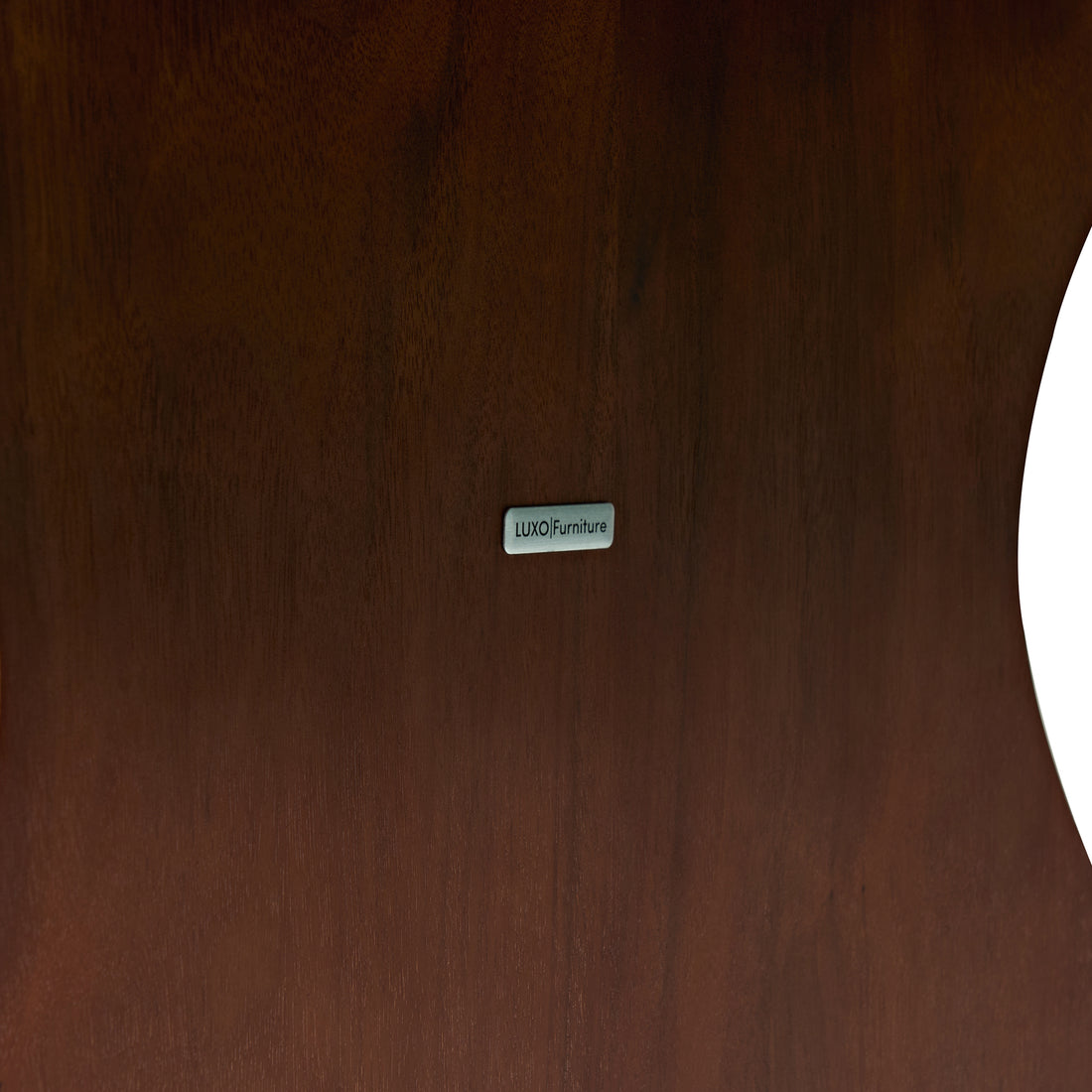 Close-up of dark wood surface with LUXO Furniture label