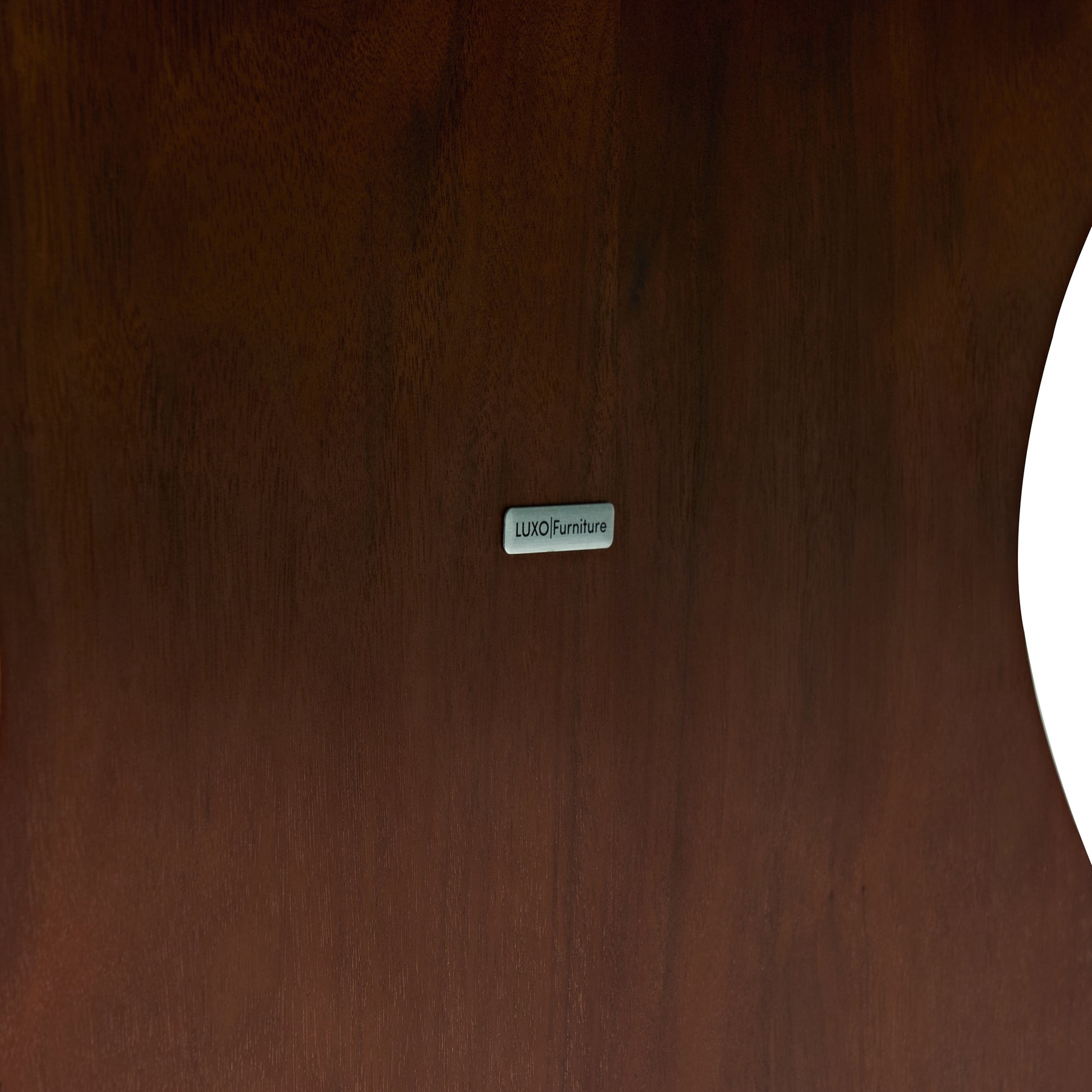 Close-up of dark wood surface with LUXO Furniture label
