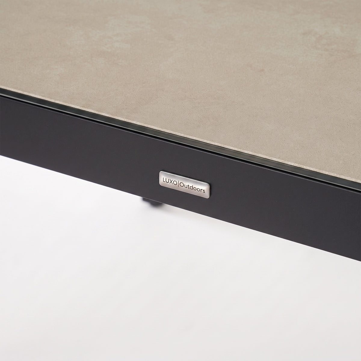 Close-up of a furniture corner with textured surface and brand logo on white background.
