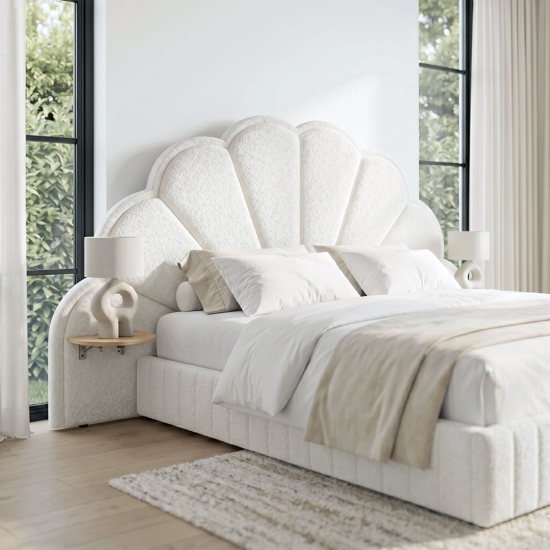 Plush white upholstered bed with shell-shaped headboard in a sunlit bedroom