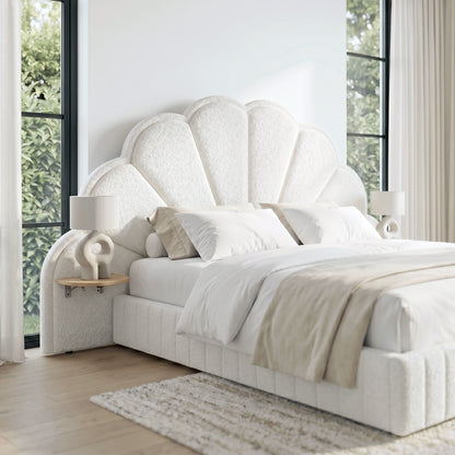 Plush white upholstered bed with shell-shaped headboard in a sunlit bedroom