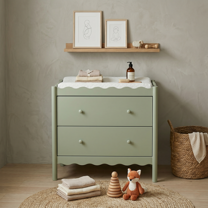 Pale green two-drawer dresser or changing table styled in a cozy children's room