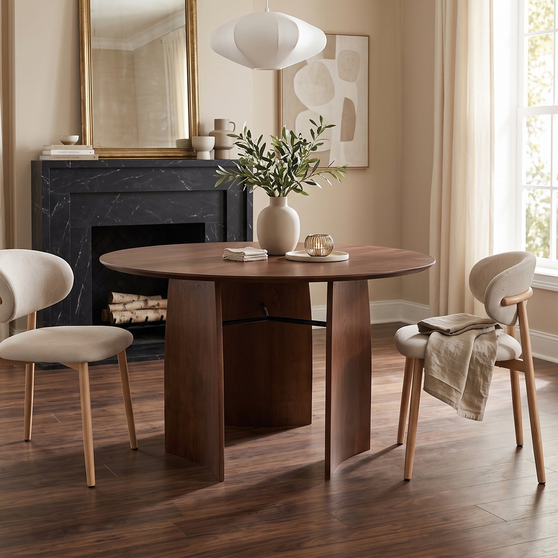 Round wooden dining table styled in a dining room with chairs and decor