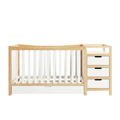 A white and natural timber crib featuring vertical slats and a storage drawer at the base.